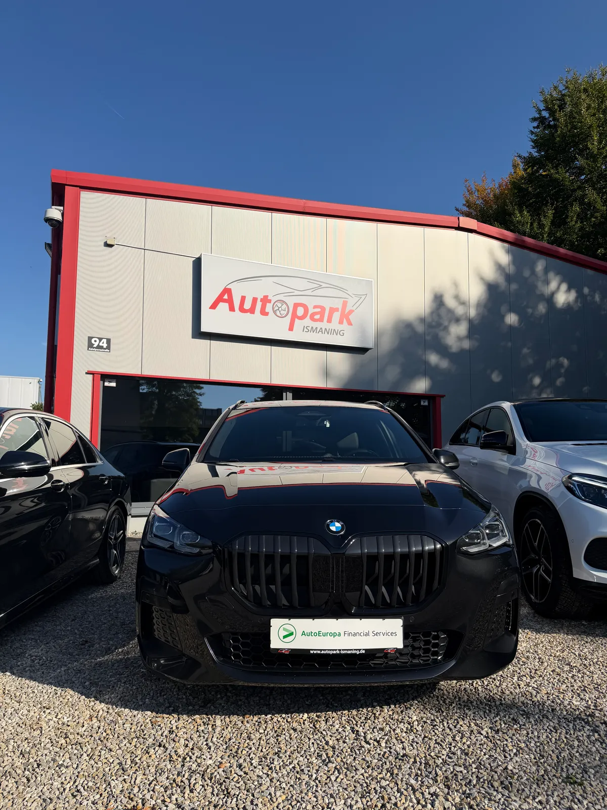 BMW vor dem Logo-Schild